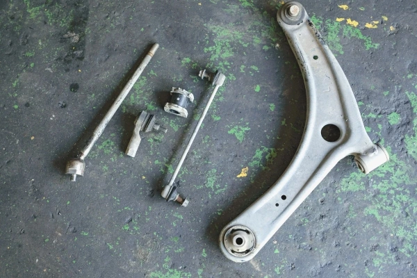 Disassembled-suspension-arm-components-including-worn-pin-and-bush