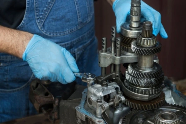 Mechanical-technician-working-on-gears-during-gearbox-servicing-showcasing-detailed-repairs