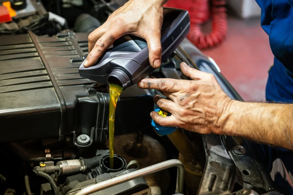 mechanic-pouring-oil-car-checks