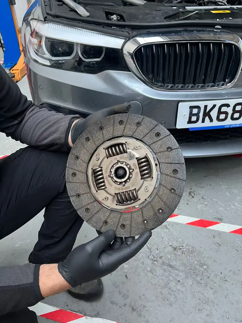 mechanic-holding-a-car-clutch-disc-during-clutch-replacement