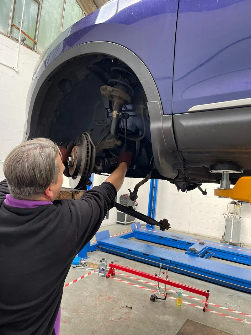 mechanic-repairing-car-suspension-and-brakes-on-a-vehicle-lift