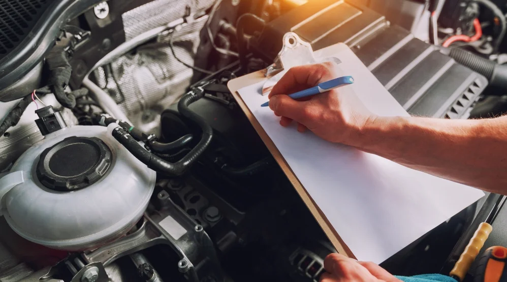 Mechanic-inspecting-a-car-engine-and-recording-the-vehicle-health-check-on-a-clipboard-for-AutoNet-VIP-Membership